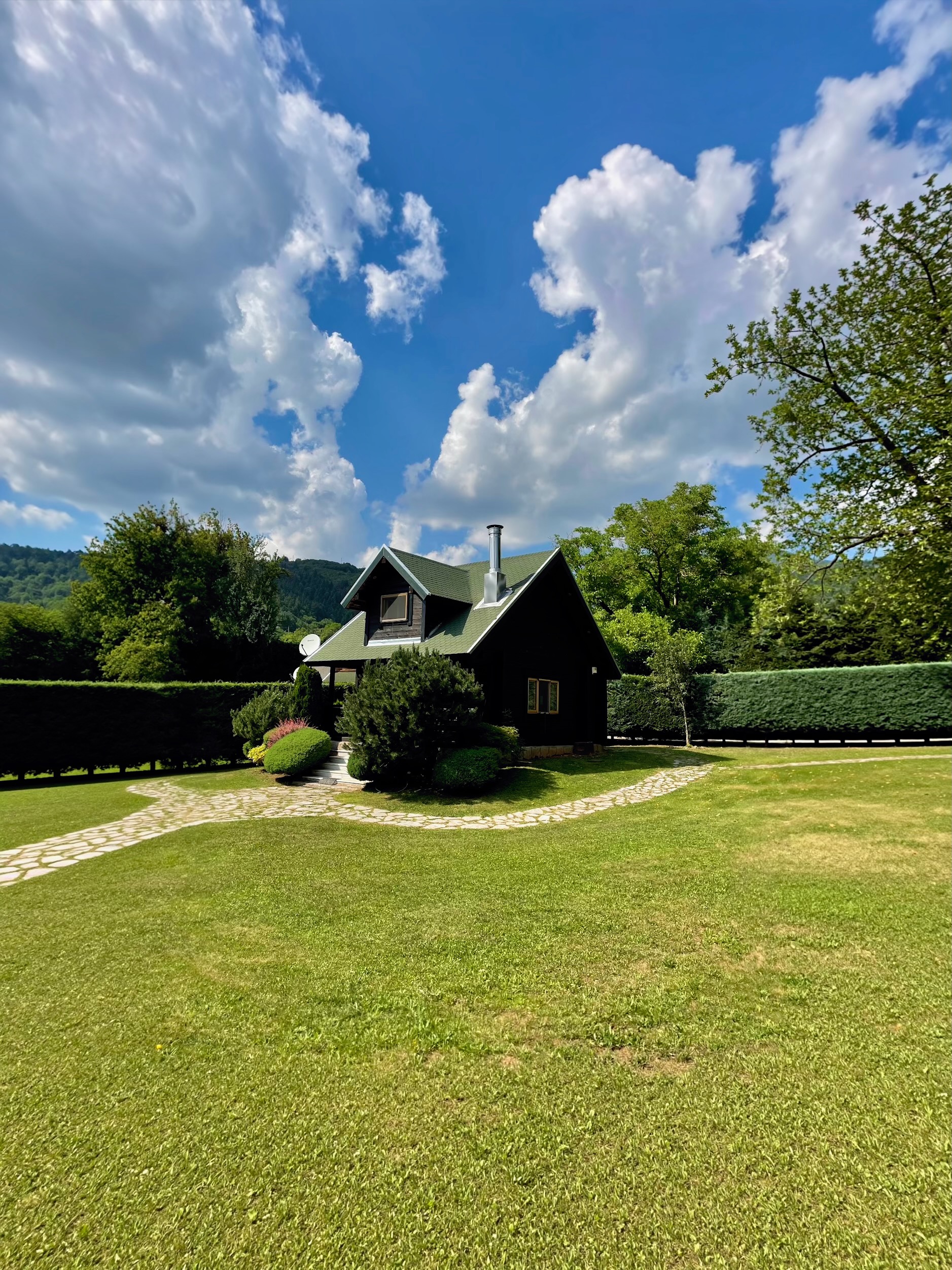 Wooden cabin with green roof on a lawn in the Karpenisi mountains